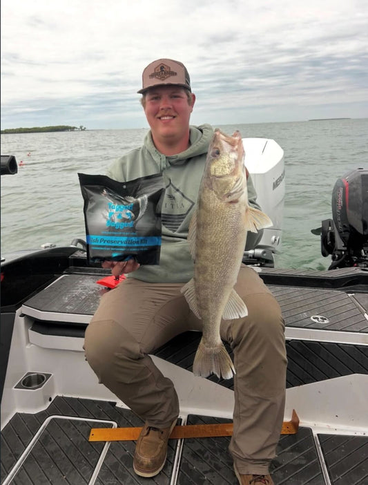 Angler holding trophy walleye with Tagged and Bagged Fish Preservation Kit